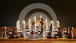 Chessboard with wooden figures, black chess figures on foreground