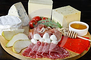 Chesse platte with different cheeses, meats on wooden board