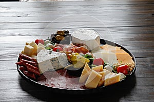 Chesse platter with cheese, prosciutto, tomato, nuts. Healthy eating, dairy, chesses and meat. Antipasti appetizer. Camembert, moz