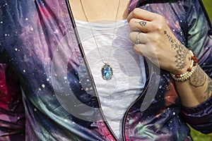 Chest detail in space jacket with labradorite pendant on silver chain