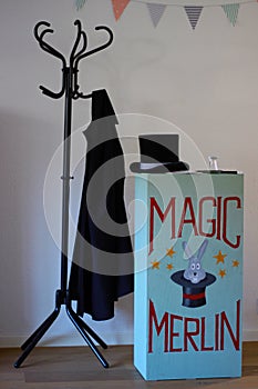 Magician stage setting. Chest of drawers with painting, stovepipe hat and coat photo