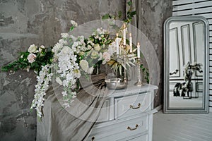 Chest of drawers decorated with flowers and candles