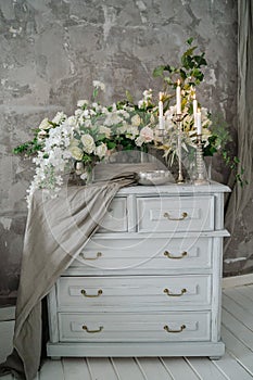 Chest of drawers decorated with flowers and candles