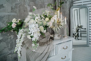 Chest of drawers decorated with flowers and candles