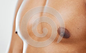 Chest, human body and man in studio to show nipple, anatomy and muscle for health, wellness and fitness of a bodybuilder