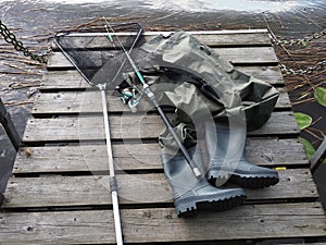 Chest waders, fish catch net and fishing rod