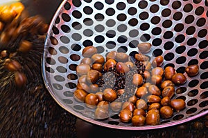 Chestnut roasting with black pebble. Traditional asian street food cooked in Yaowarat Road or China town, Bangkok ,Thailand