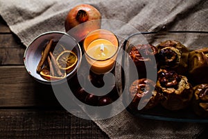 Chestnuts, candle, cinnamon, and orange in a bowl