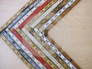 Chevron graph made of folding rulers in metric and inches representing accuracy, measurement, decrease