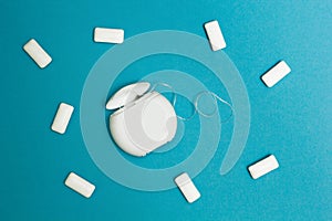 Chewing gum and dental floss on a blue background