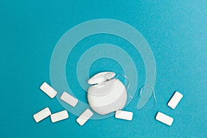 Chewing gum and dental floss on a blue background. Space for text