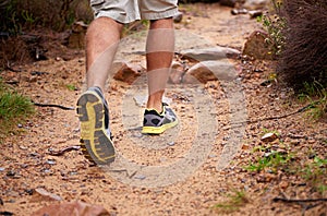 Chewing up the trail. a mans legs as he hikes up a rocky trail.