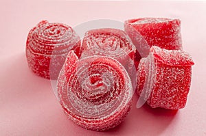 Chewy sweets and strawberry and cherry flavoured gummy candy concept with close up on sweet and sour red sour belts covered in