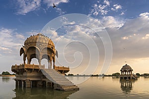 Chhatris and shrines of hindu Gods and goddesses at Gadisar lake, Jaisalmer, Rajasthan, India with reflection on water. Indo-