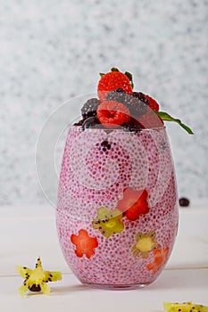 Chia Pudding for breakfast in glass jars garnished with berry portions