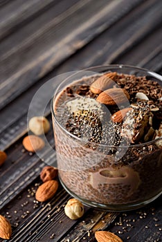 Chia pudding with chocolate banana smoothie in a glass jar on the old wooden background