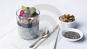 Chia pudding dessert with raspberry jam and granola, mint, blueberry, raspberry on the top