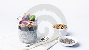 Chia pudding dessert with raspberry jam and granola, mint, blueberry, raspberry on the top