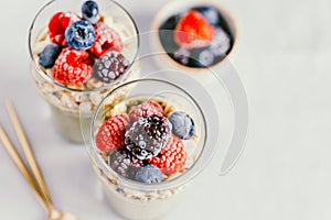 Chia pudding with matcha tea, organic granola, frozen berries in glass