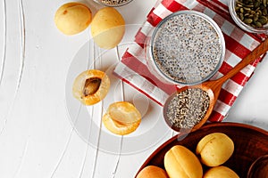 Chia pudding and raw chia seeds on white table