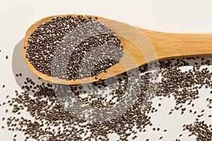 Chia Seed. Healthy grains on a wooden spoon. White background.