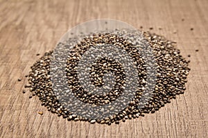 Chia Seed. Pile of grains on the wooden table. Selective focus.