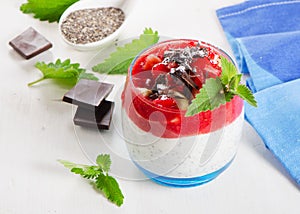 Chia seed pudding with berries and chocolate on white wooden t