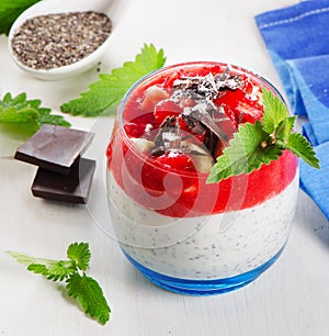 Chia seed pudding with berries and chocolate on white wooden t