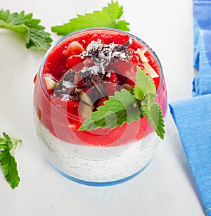 Chia seed pudding with berries and chocolate on wooden table.