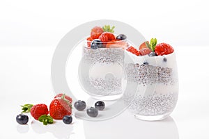Chia seed pudding with berries on white background, raspberry, strawberry, blueberry.