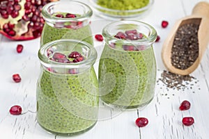 Chia seed pudding with matcha green tea, garnished with pomegranate