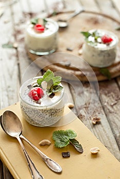 Chia seed pudding with raspberries chocolate and mint in jars.