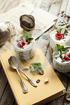 Chia seed pudding with raspberries chocolate and mint in jars. Close up