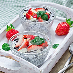 Chia seed pudding with strawberries, almond and chocolate cookie crumbs, square format