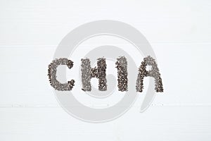 Chia seeds. Chia word made from chia seeds with spoon full of chia in a bowl.