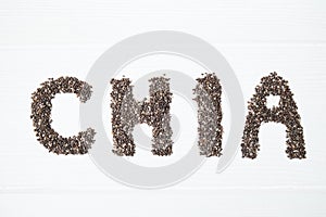 Chia seeds. Chia word made from chia seeds with spoon full of chia in a bowl.