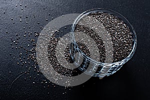 Chia seeds in a cup beautifully laid out on a black background. Top view. copy space. Vegetarian food