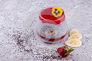 Chia seeds with fresh banana and strawberry in glass. Copy space