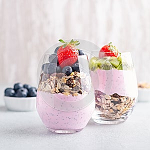 Chia seeds pudding with granola, blueberry and strawberry in glasses. Yogurt with chia seeds, berries, kiwi and muesli