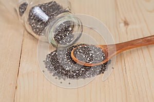 Chia seeds spilling out of glass bottle on able