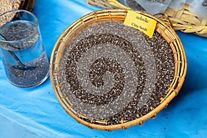 Chia seeds in the vintage wooden bamboo basket with label caption word `Chia seeds`