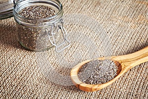 Chia seeds in a wooden spoon and jar.