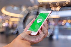 CHIANG MAI, THAILAND - May.10,2019: Woman holding Apple iPhone 6S Rose Gold with LINE apps on screen. LINE is a new communication