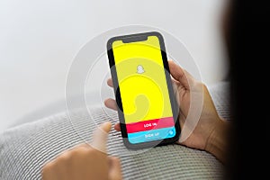 CHIANG MAI, THAILAND, Sep 06, 2023 : Snapchat application icon on Apple iPhone X smartphone screen close-up in woman