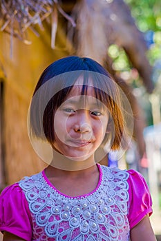 CHIANG RAI, THAILAND - FEBRUARY 01, 2018: Close up of unidentified smiling little girl belongs to a Karen Long Neck hill