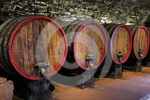 Chianti wine aging in wooden barrels at a vineyard cellar in Tuscany, Italy