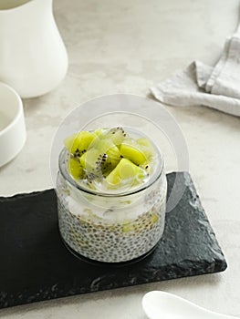 Chiaseed served in a glass jar topped with yogurt and kiwi fruit.