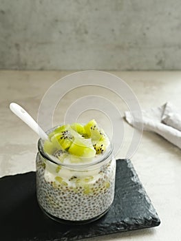 Chiaseed served in a glass jar topped with yogurt and kiwi fruit.