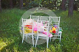 Chiavari chairs on grass with bouquet flowers photo