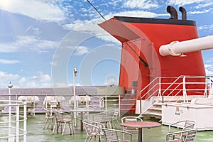 Large orange chimney and roof-deck with tables and chairs on the kanayamaru ferry.